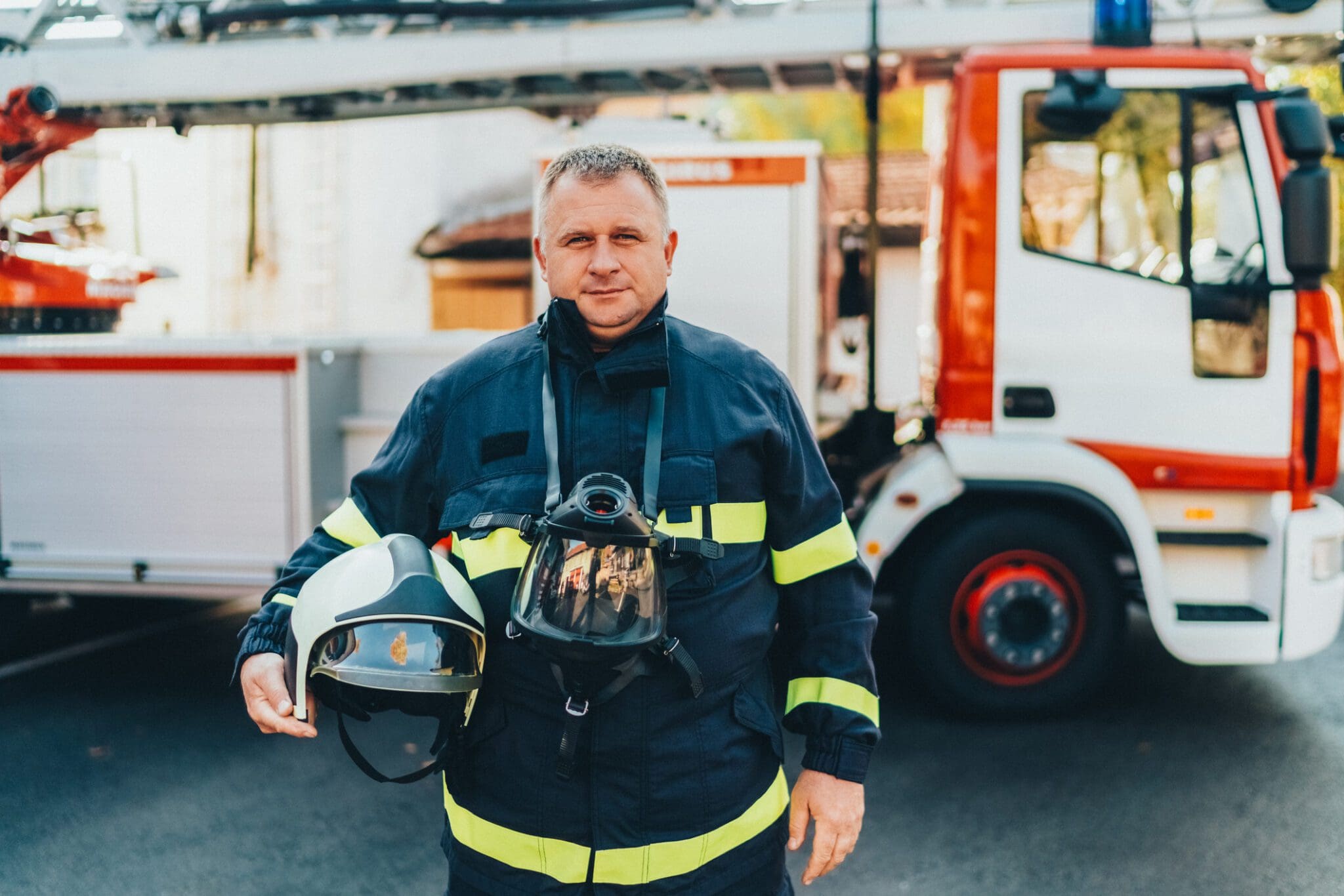 Firefighter in uniform beside fire engine